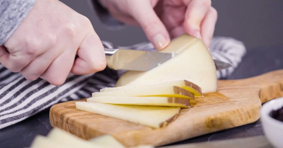 corte de quesos en cuña con cuchillo filo