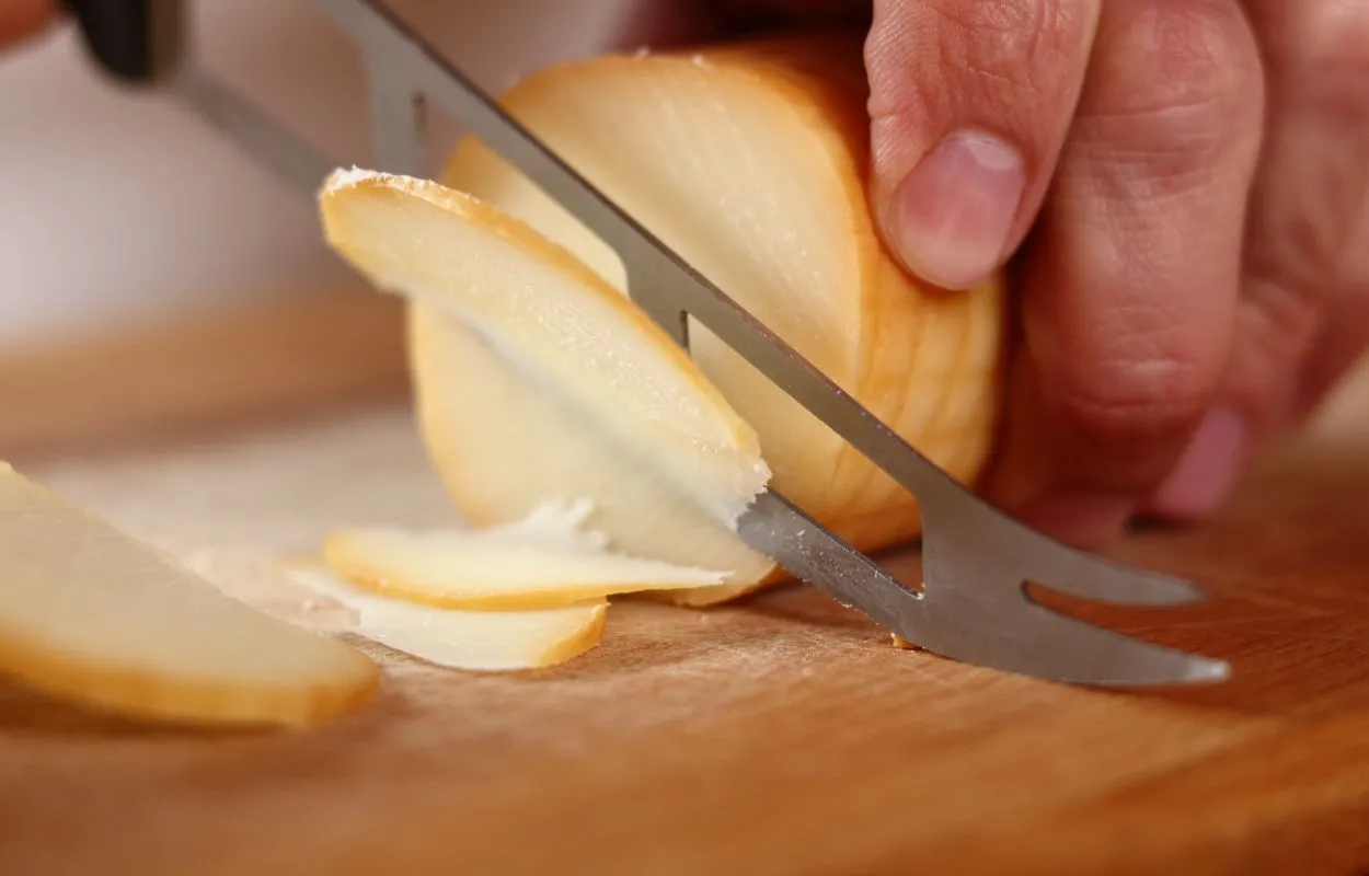 cortando un queso scarmoza affumicata